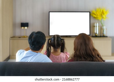 Happy Asian family with father, mother and daughter enjoy weekend activity spending more time at home and therefore probably more time in front of the television - Powered by Shutterstock