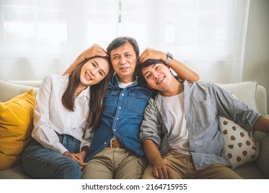 Happy Asian Family, Father And Son And Daughter Sitting On Sofa In Living Room.