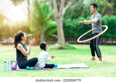 Happy asian family in the garden, Father, Mother and doughter. They are having fun playing hula hoop in home garden together - Powered by Shutterstock