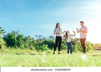 Happy Asian Family In The Garden They Are Having Fun Playing And Blowing Bubbles.