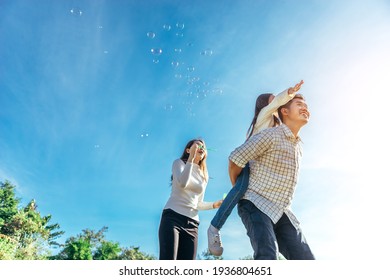Happy asian family in the garden They are having fun playing and blowing bubbles. - Shutterstock ID 1936804651