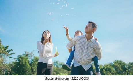 Happy asian family in the garden They are having fun playing and blowing bubbles. and enjoyed ourselves together in the green garden. Family enjoying sunny fall day in nature. - Powered by Shutterstock