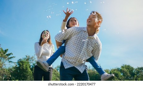 Happy Asian Family In The Garden They Are Having Fun Playing And Blowing Bubbles. And Enjoyed Ourselves Together In The Green Garden. Family Enjoying Sunny Fall Day In Nature.