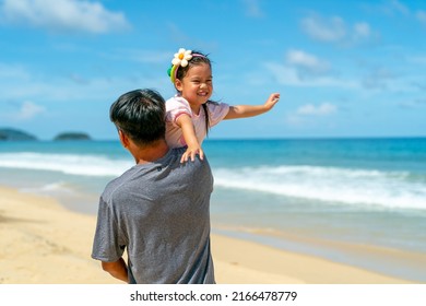 Happy Asian Family Grandfather Carrying And Playing With Little Grandchild Girl While Walking On The Beach On Summer Vacation. Senior Man And Child Girl Kid Enjoy Outdoor Lifestyle Together At The Sea