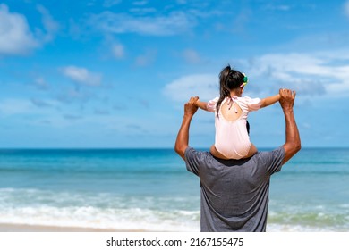 Happy Asian Family Grandfather Carrying And Playing With Little Grandchild Girl While Walking On The Beach On Summer Vacation. Senior Man And Child Girl Kid Enjoy Outdoor Lifestyle Together At The Sea