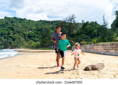 Happy Asian Family Grandfather Jogging Exercise With Little Grandchild Boy And Girl On Tropical Beach. Healthy Senior Man And Children Kid Enjoy Outdoor Activity Sport Training On Summer Vacation