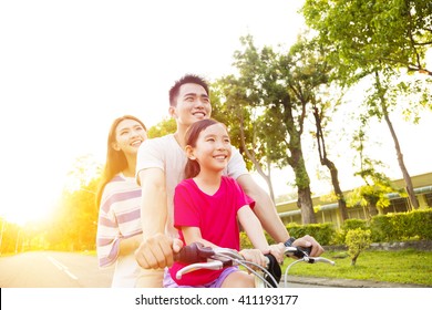 Happy Asian Family Having Fun In Park With Bicycle