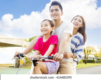 Happy Asian Family Having Fun In Park With Bicycle