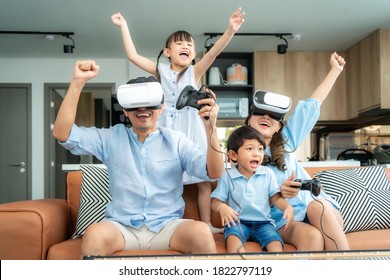 Happy Asian family at home on living room sofa having fun while they are looking mother and father playing games using virtual reality headset VR in living room at home. - Powered by Shutterstock