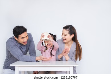 Happy Asian Family Inserting Coins To Box Over White Background For Saving Money Concept