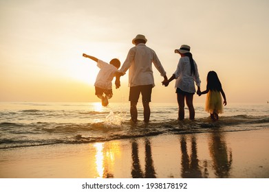 Happy asian family jumping together on the beach in holiday. Silhouette of the family holding hands enjoying the sunset on the  beach.Happy family travel and vacations concept.  - Shutterstock ID 1938178192