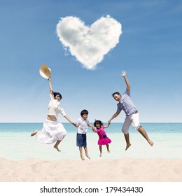 Happy Asian Family Jumping Under Love Cloud At Beach