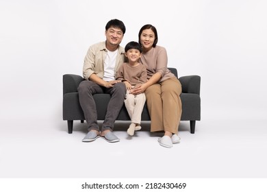 Happy Asian Family With Little Son Sitting On Sofa Together Isolated On White Background