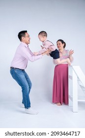 Happy Asian Family , Little Todler Son Jumping To His Dad In Studio Shot