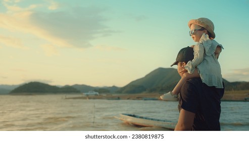 happy asian Family Love Father Carrying Daughter on Shoulder Embracing and watching Golden Hour Joy sunset together on Beachside, Share Precious Sunset Beach Moment - Powered by Shutterstock