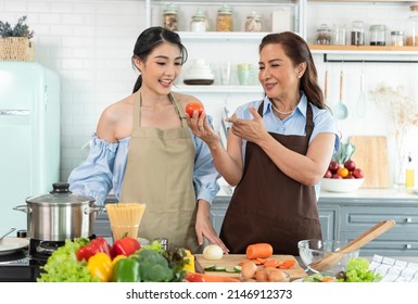 Happy Asian Family Making Salad In Kitchen At Home. Enjoy Family Activity Together.