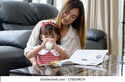 Happy Asian Family Mom And Daughter Drink Milk At Home