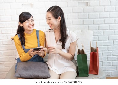 Happy Asian Family Mom And Teenage Daughter Using Smart Phone Online Shopping With Credit Card In A Room With Nature Sunlight At House. Shopping At Home Concept. With Copy Space