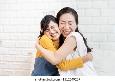 Happy Asian Family Mom And Teenage Daughter Embrace Together Excited, Glad In A Room That Has Sunlight From The Window At Home. Show Love Family Concept