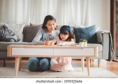 Happy Asian Family Mother And Daughter Study Or Drawing Together At Home In Living Room