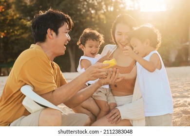 Happy Asian Family On The Beach At Sunset Time, Asian Twins Boy Playing With Parents On The Beach.