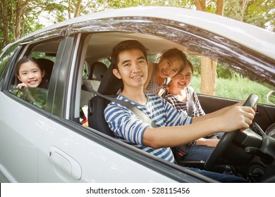 Happy Asian family on mini van are smiling and driving for travel on vacation