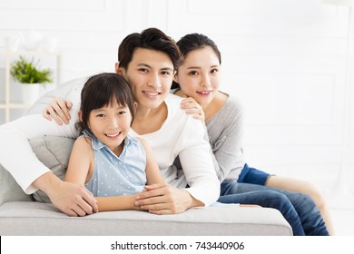 Happy Asian Family On Sofa In Living Room
