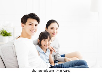 Happy Asian Family On Sofa In Living Room