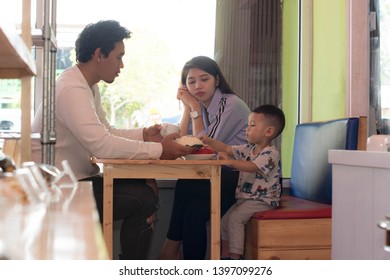 Happy Asian Family, With One Todler Spending Time Together Inside Bakery Store And Cafe Eating Cake, Family Bonding Time