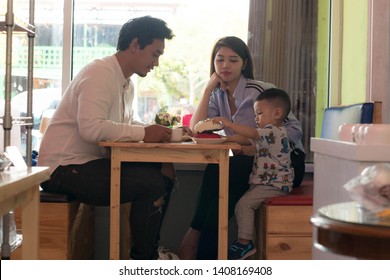 Happy Asian Family, With One Todler Spending Time Together Inside Bakery Store And Cafe Eating Cake, Family Bonding Time