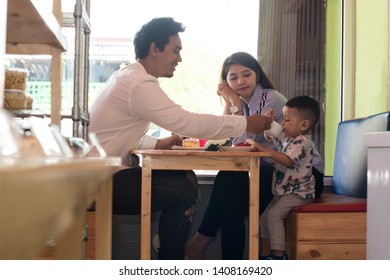 Happy Asian Family, With One Todler Spending Time Together Inside Bakery Store And Cafe Eating Cake, Family Bonding Time