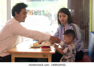 Happy Asian Family, With One Todler Spending Time Together Inside Bakery Store And Cafe Eating Cake, Family Bonding Time