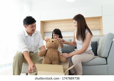 Happy Asian Family Open Or Unpacking Parcel Box Together For Surprise Gift For Little Girl Or Kids, Parent Buy Order Big Teddy Bear Doll From Shopping Online Application For Children At Home 