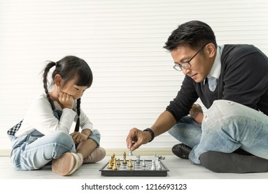 Happy Asian Family Playing Chess Together.