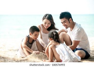 Happy Asian Family Playing on the beach