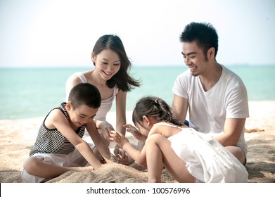 Happy Asian Family Playing On The Beach