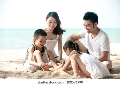 Happy Asian Family Playing On The Beach