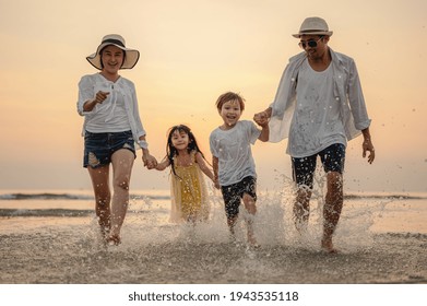 Happy Asian Family Playing Sea On The Beach At Sunset.Family Who Enjoy A Picnic.Family, Travel,beach, Relax,lifestyle, Holiday Concept. 