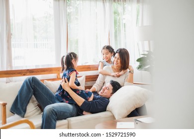 Happy Asian Family Playing Together At Sofa, Home Living Room