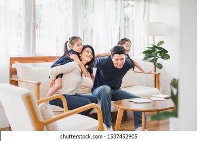 Happy Asian Family Playing Together At Sofa, Home Living Room