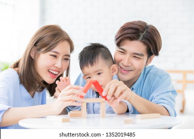Happy Asian Family Playing With Toy Blocks And 