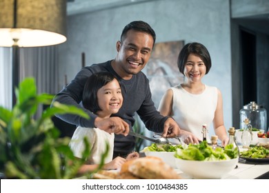 Happy Asian Family Preparing Food In The Kitchen.