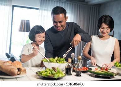 Happy Asian Family Preparing Food In The Kitchen.