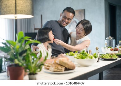 Happy Asian family preparing food in the kitchen. - Powered by Shutterstock