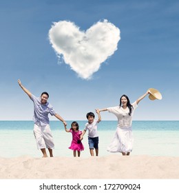 Happy Asian Family Run At Beach Under Love Cloud