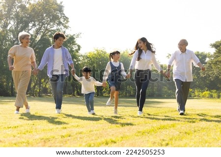 Happy Asian family running in the park, Outdoor with big family and summer season concept 