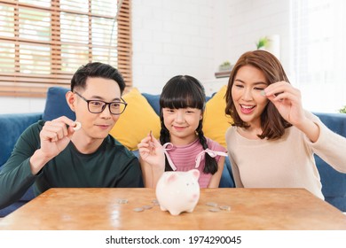 Happy Asian Family Saving Money In Piggy Bank Pig. Investment For Future Concept.