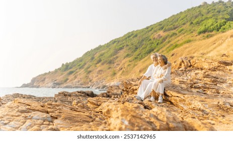 Happy Asian family senior couple enjoy outdoor lifestyle travel nature ocean relaxing together at tropical island beach on summer holiday vacation. Elderly people health care and wellbeing concept. - Powered by Shutterstock