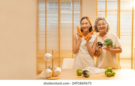 Happy Asian family shopping grocery and vegetables at market together. Portrait of Mother and daughter unpacking vegetables and food in cotton sustainable reusable mesh bag in the kitchen at home. - Powered by Shutterstock