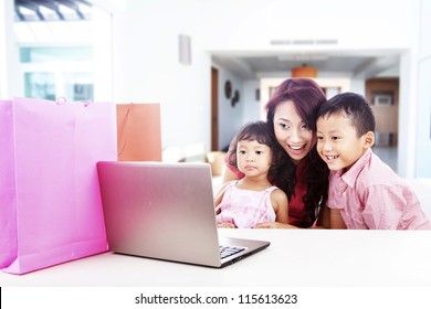 Happy Asian Family Shopping Online By Using Laptop Computer, Shot At Home